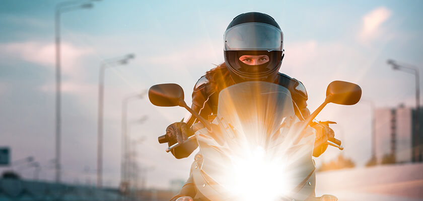 Female motorcyclist wearing a helmet on the freeway