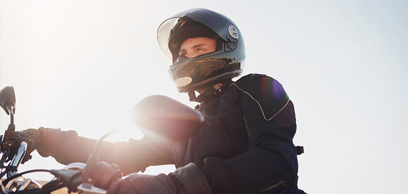 Man wearing helmet riding a motorcycle