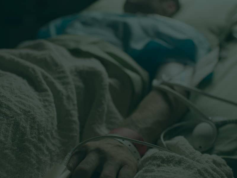 Man in hospital bed with spinal injury